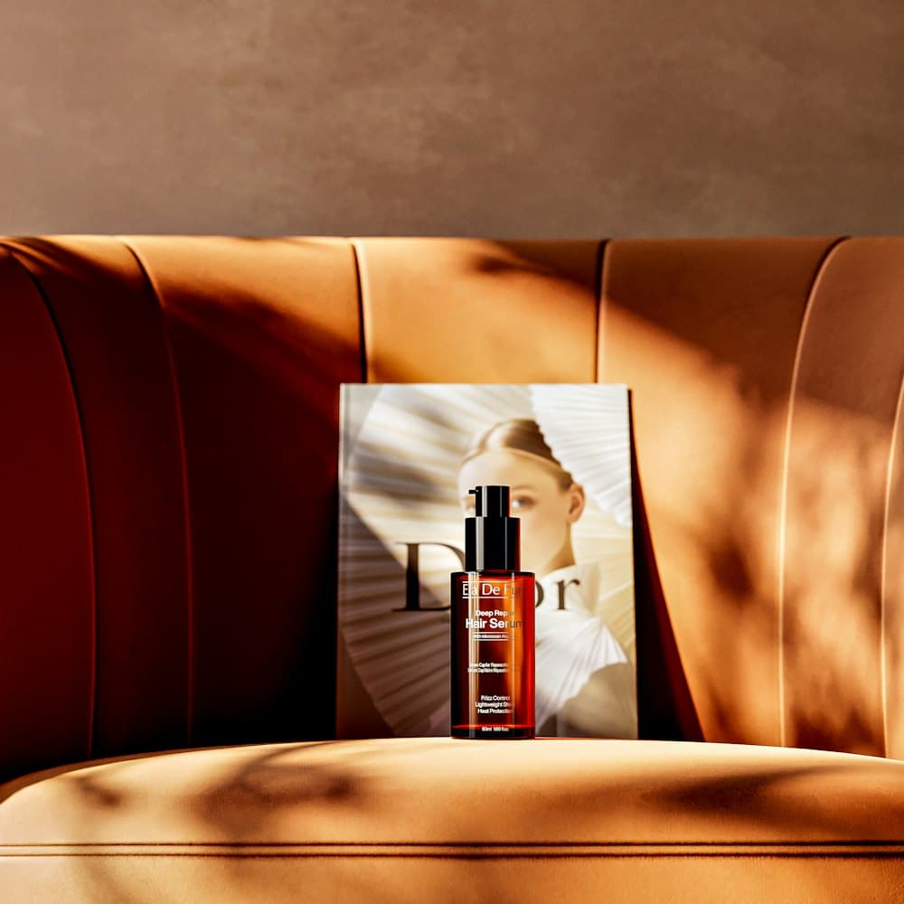 Skincare serum on a tan velvet sofa