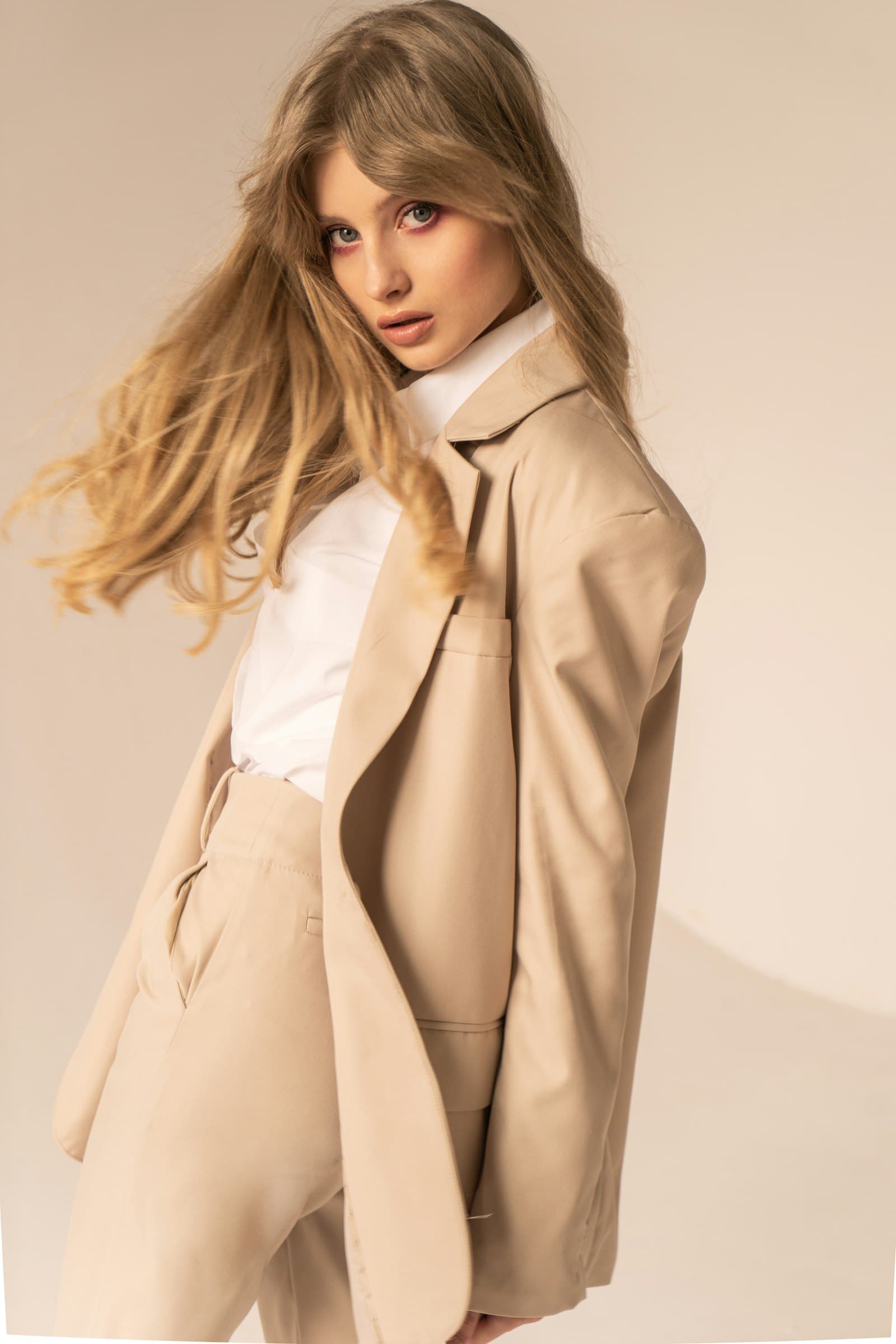 Model in a tailored beige linen suit