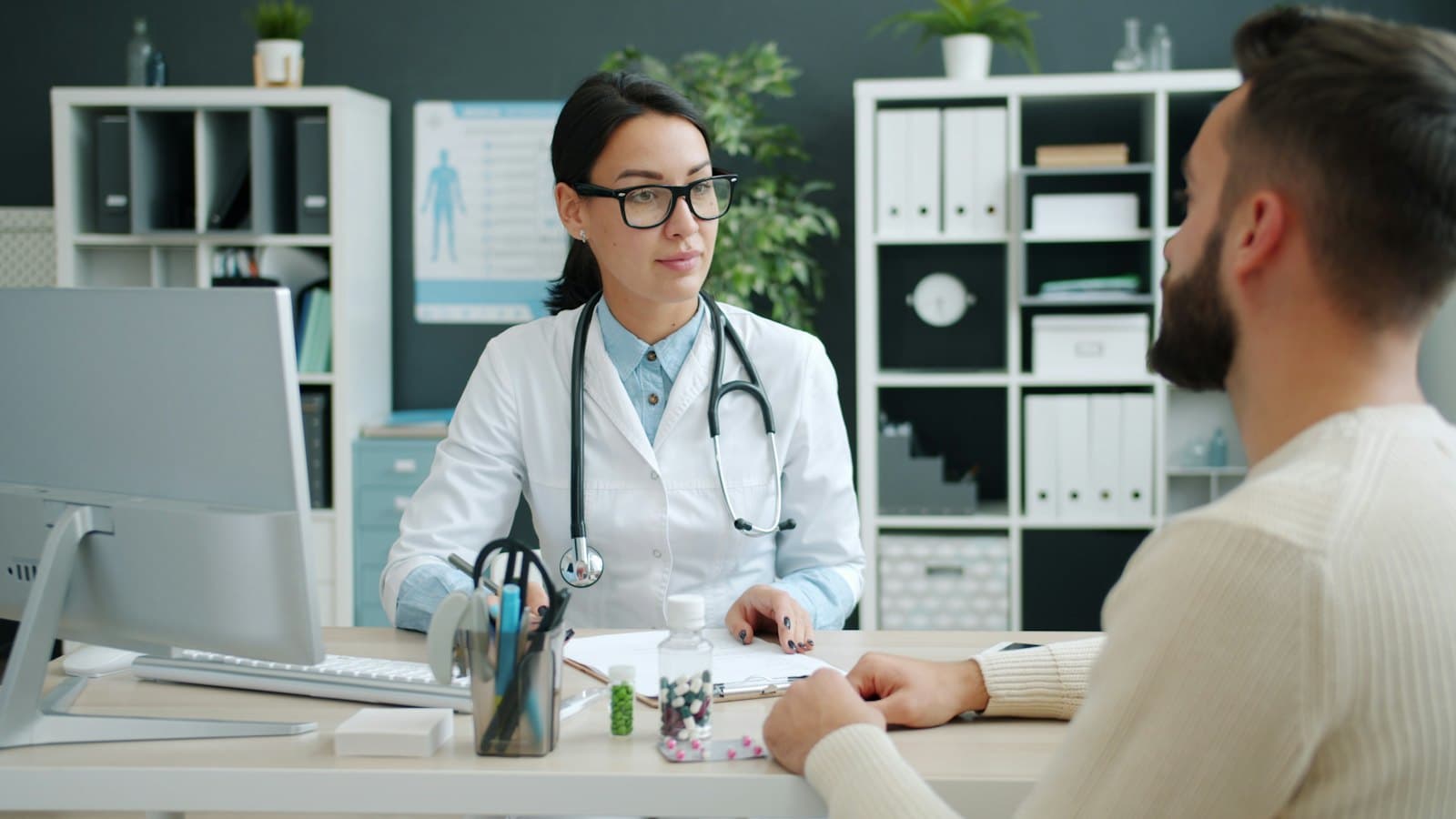 A doctor talking with a patient across her desk