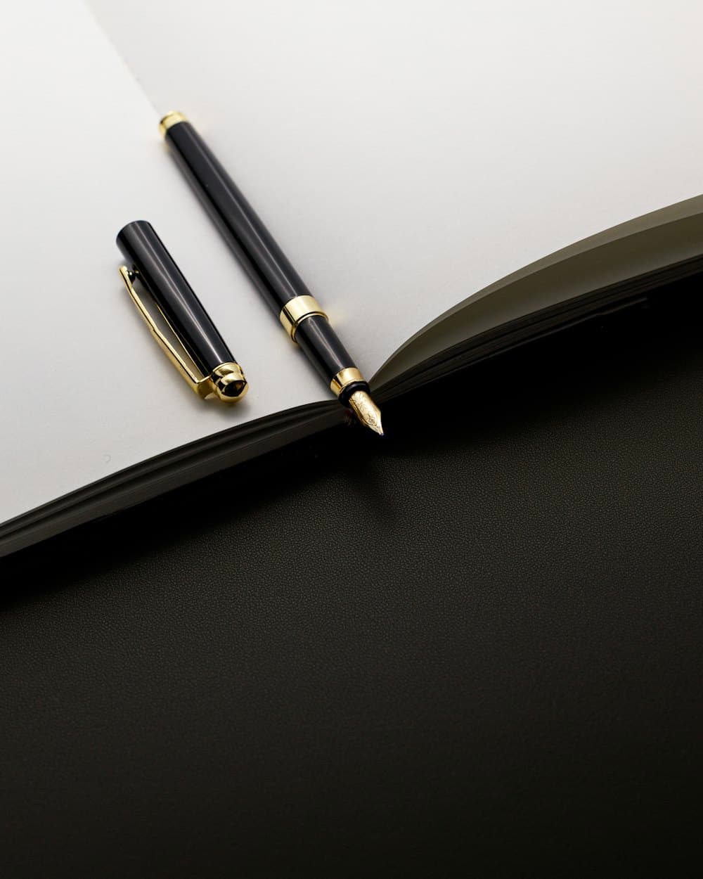 A fountain pen resting on an open notebook