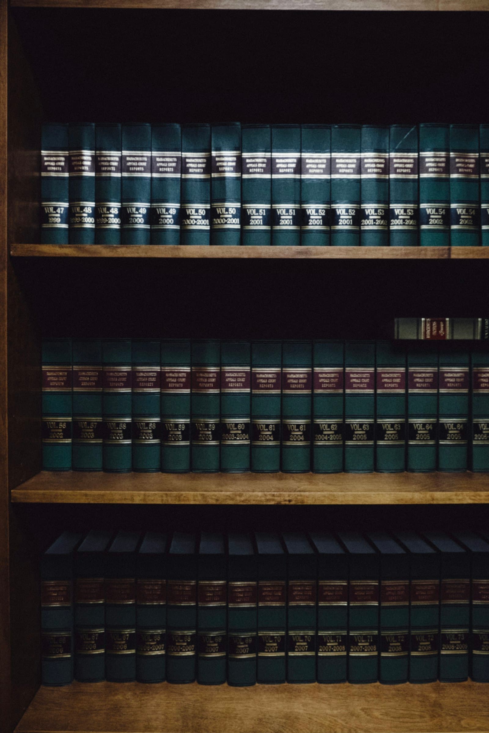 Rows of bound law reports on wooden shelves